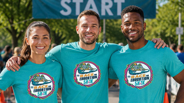 Three people wearing matching teal t-shirts with a race logo at a start line event.