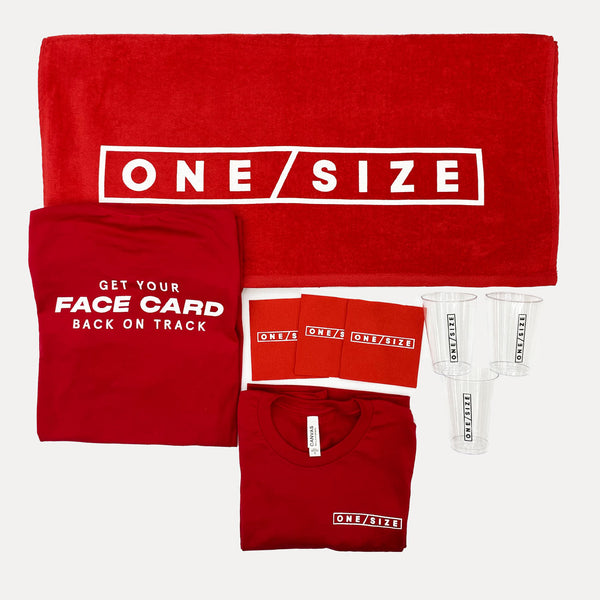 A red gift set featuring a large towel, a folded T-shirt, a folded T-shirt with a face card insert, three small plastic cups, and folded T-shirts, all printed with the white text 'ONE SIZE'.